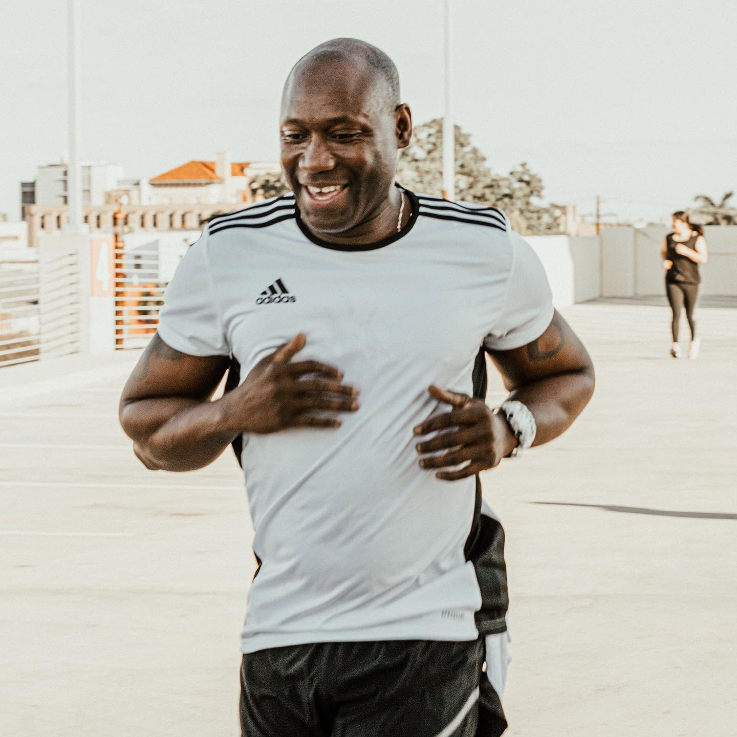 Alex Ampadu smiling mid-run — the trainer behind every personalized 101 Fitness online program, based in Brownsville, TX