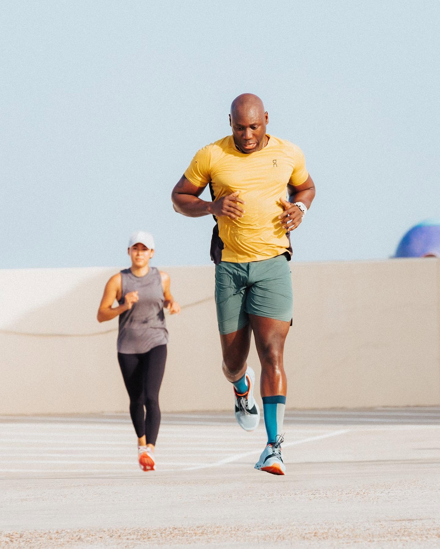 Alex 'Mr. 101' Ampadu leading a client through a running workout — the same coaching 101 Fitness online clients get anywhere