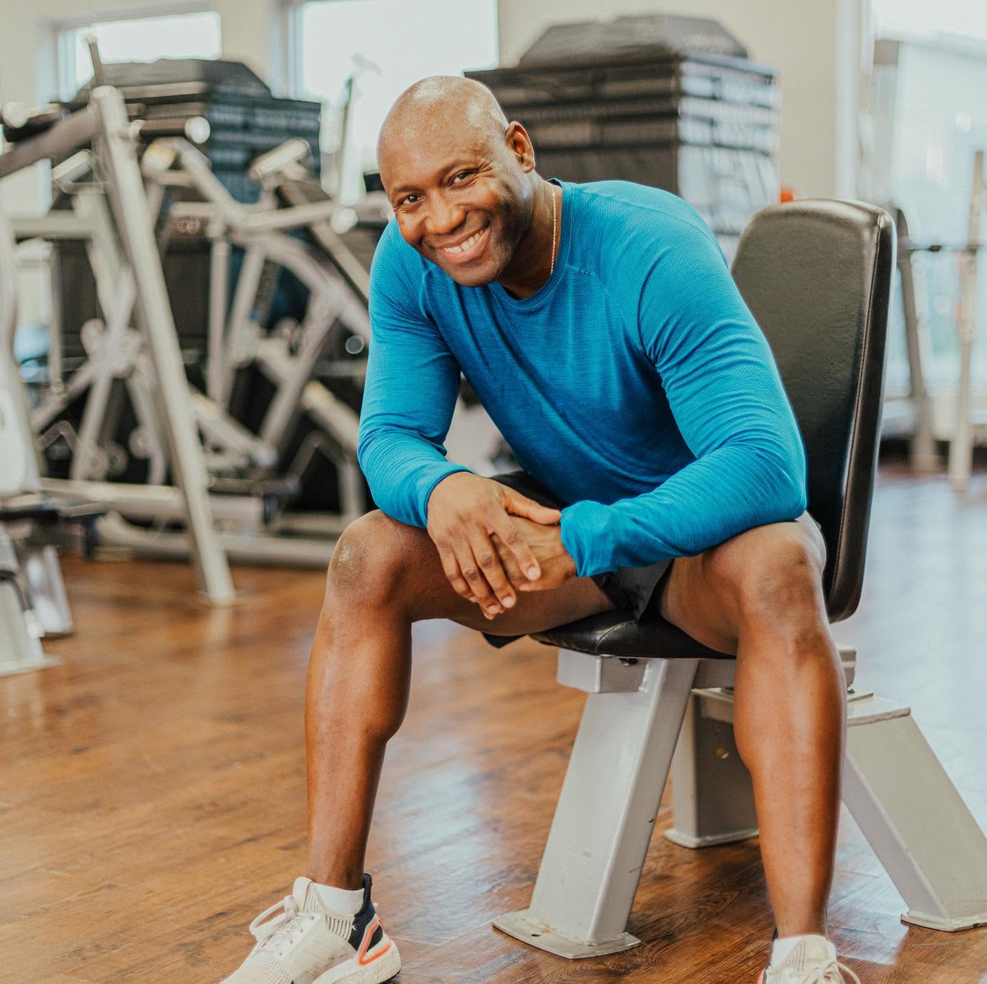 Alex 'Mr. 101' Ampadu seated in his private Brownsville studio with a warm smile — senior training without the big-gym intimidation