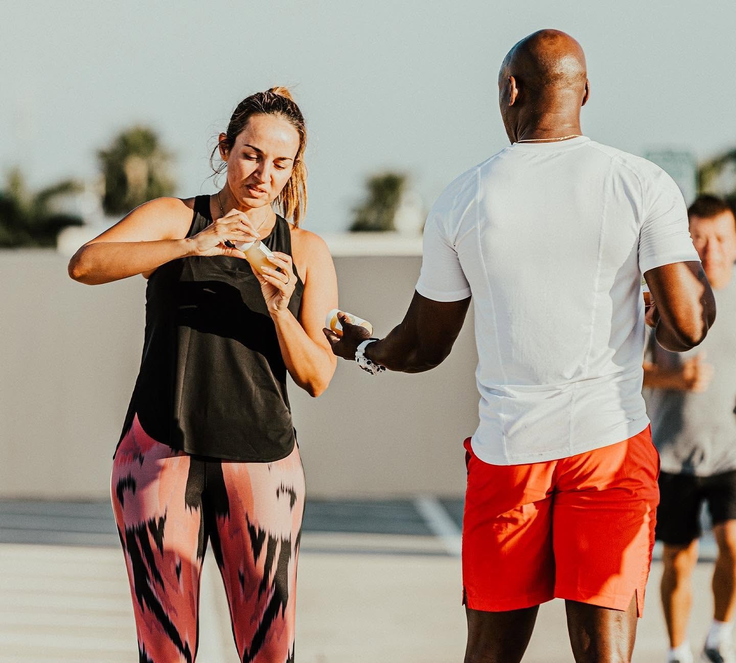 Alex 'Mr. 101' Ampadu coaching a client one-on-one during an outdoor 101 Fitness session in Brownsville